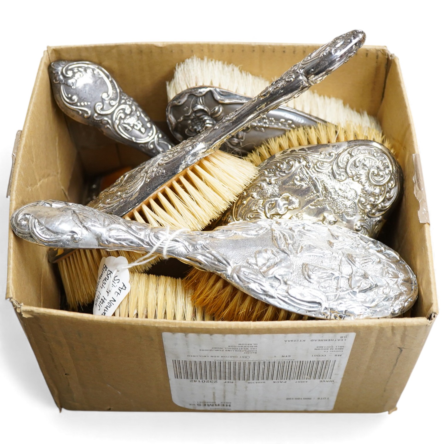 An Edwardian repousse silver mounted six piece dressing table mirror, brush and comb set, by Henry Matthews, Birmingham 1901, together with one other silver mounted hair brush and clothes brush.